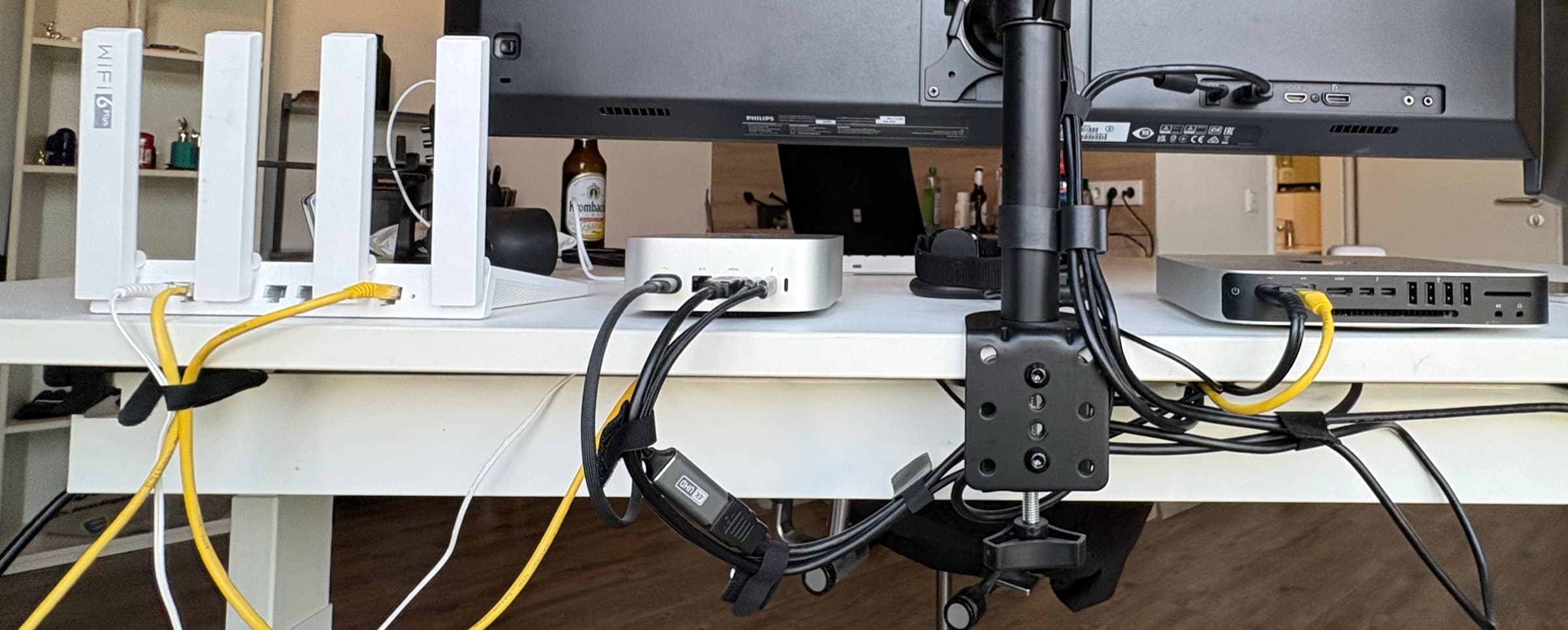 The server under my desk — a 2014 Mac Mini turned into a self-hosted cloud, wired into the home network over hand-run Ethernet beside the Wi-Fi 6 router.